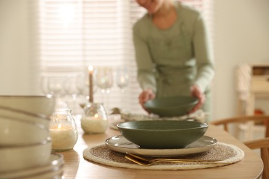 Photo of Woman setting table for dinner at home, closeup