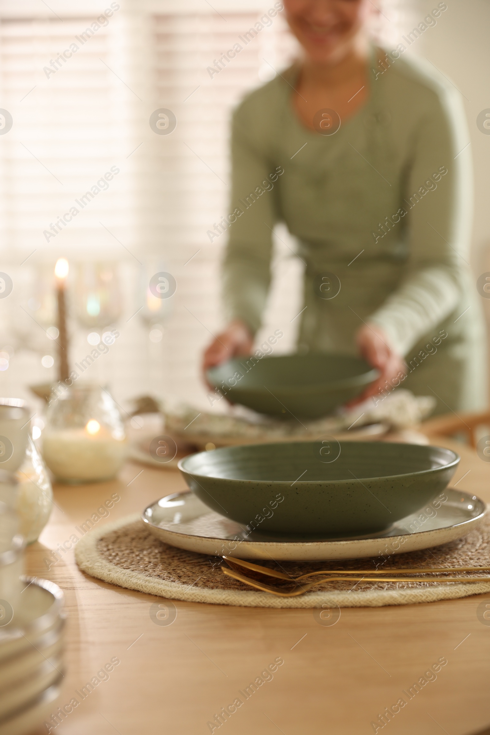 Photo of Woman setting table for dinner at home, closeup