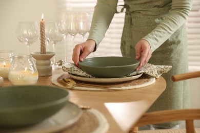 Photo of Woman setting table for dinner at home, closeup