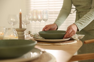 Photo of Woman setting table for dinner at home, closeup