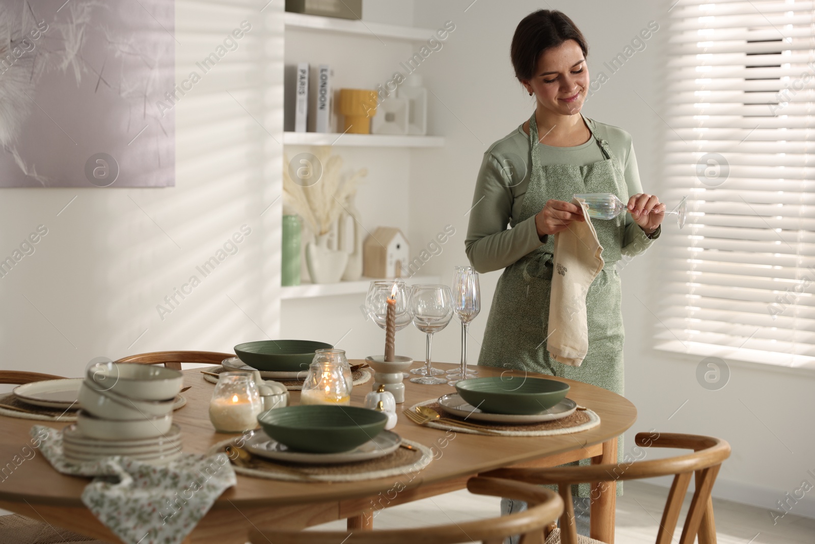 Photo of Woman setting table for dinner at home