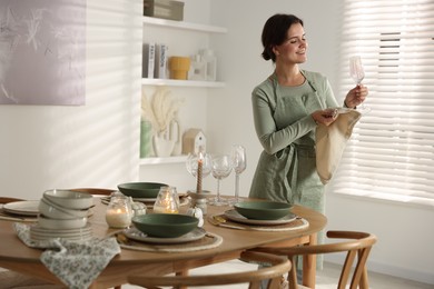 Photo of Woman setting table for dinner at home