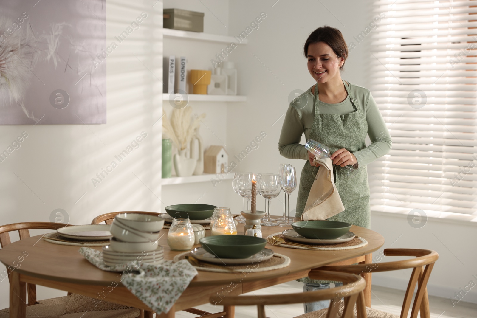 Photo of Woman setting table for dinner at home