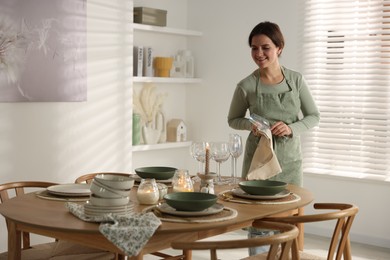 Photo of Woman setting table for dinner at home