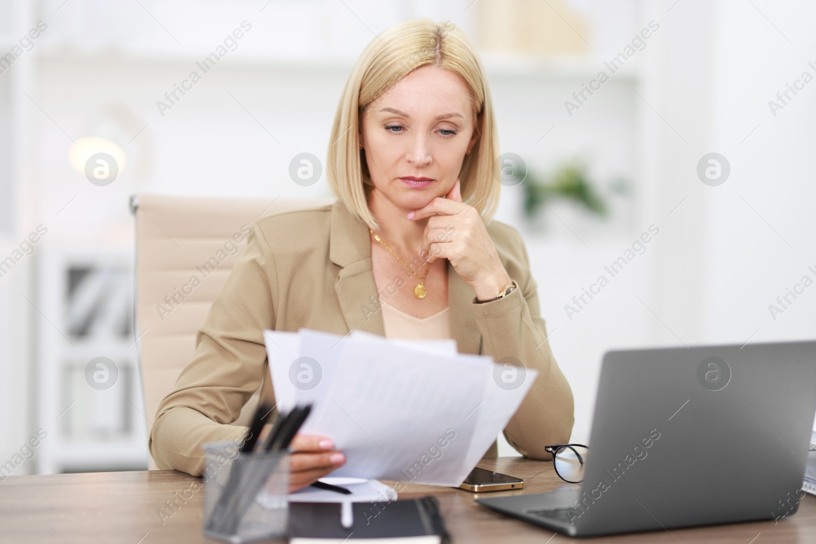 Photo of Middle aged woman working at table in office