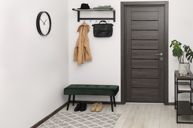 Photo of Mirror, houseplant and bench in stylish hallway