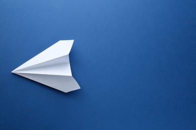 One handmade paper plane on blue background, top view. Space for text