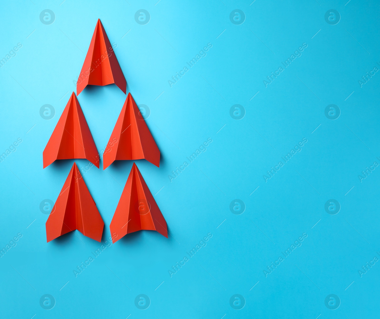 Photo of Handmade red paper planes on light blue background, top view. Space for text