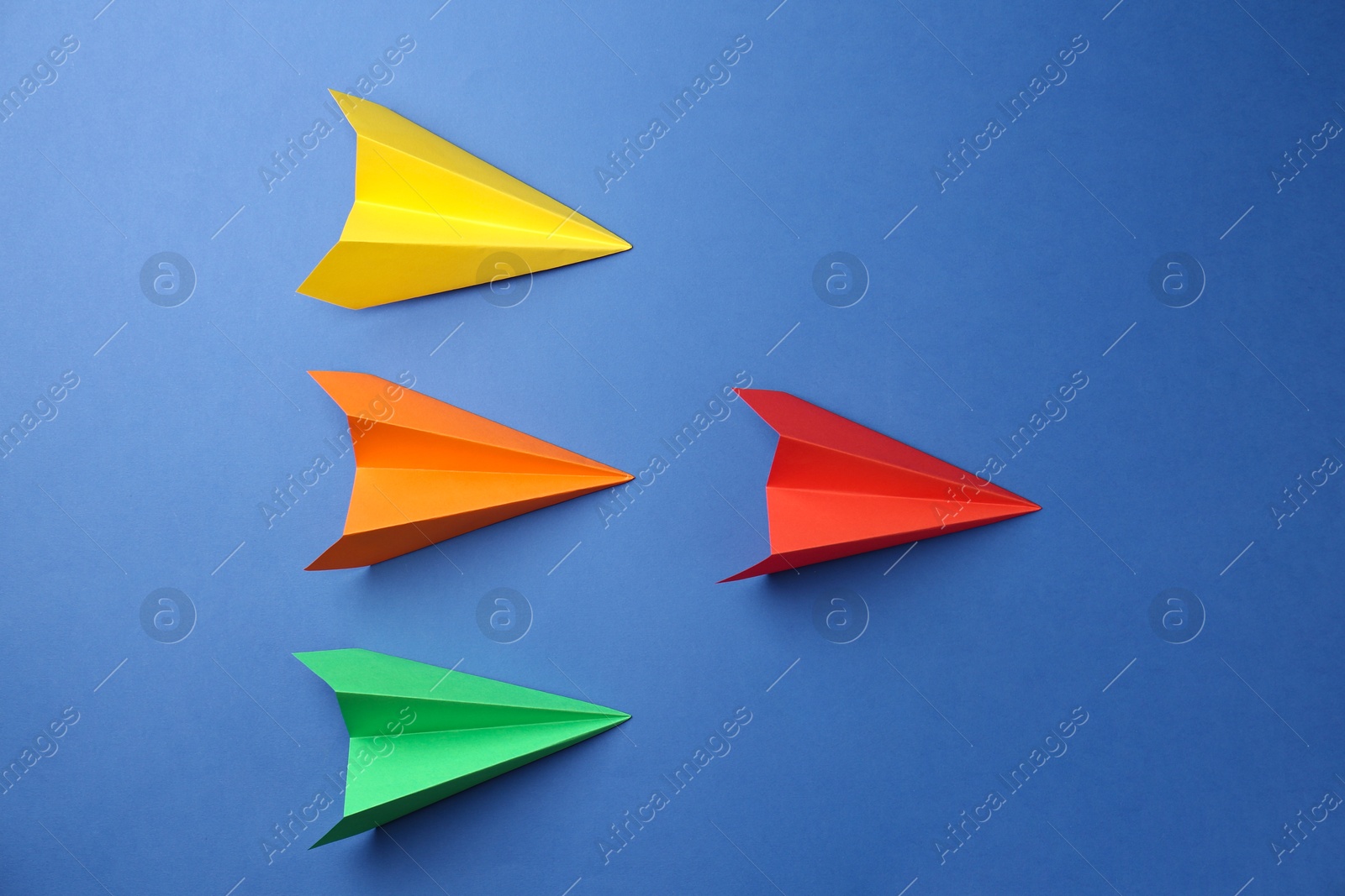 Photo of Handmade color paper planes on blue background, flat lay