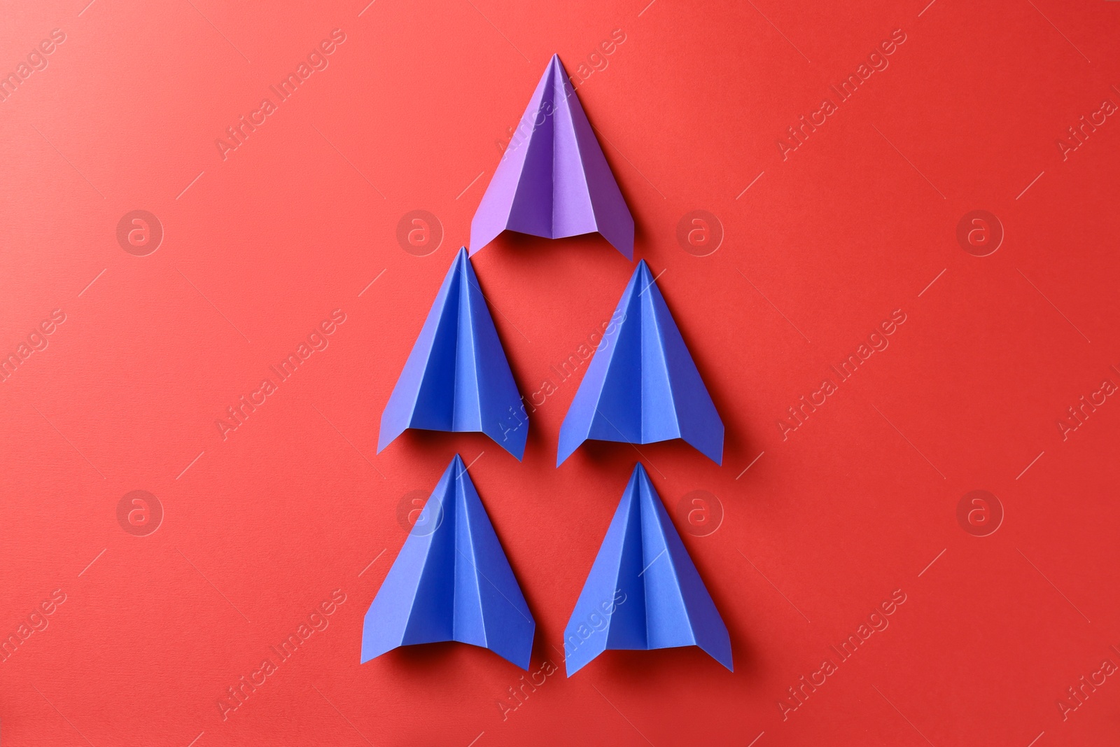 Photo of Colorful paper planes on red background, top view