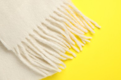 Photo of Warm woolen scarf on yellow background, top view