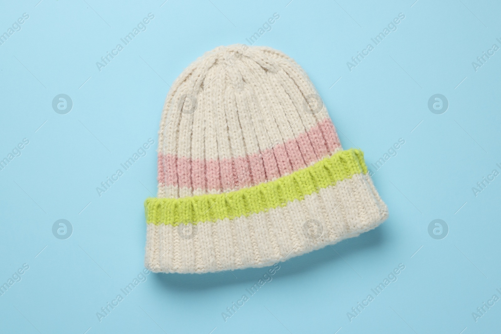 Photo of Warm woolen hat on light blue background, top view