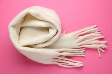 Photo of Warm woolen scarf on pink background, top view