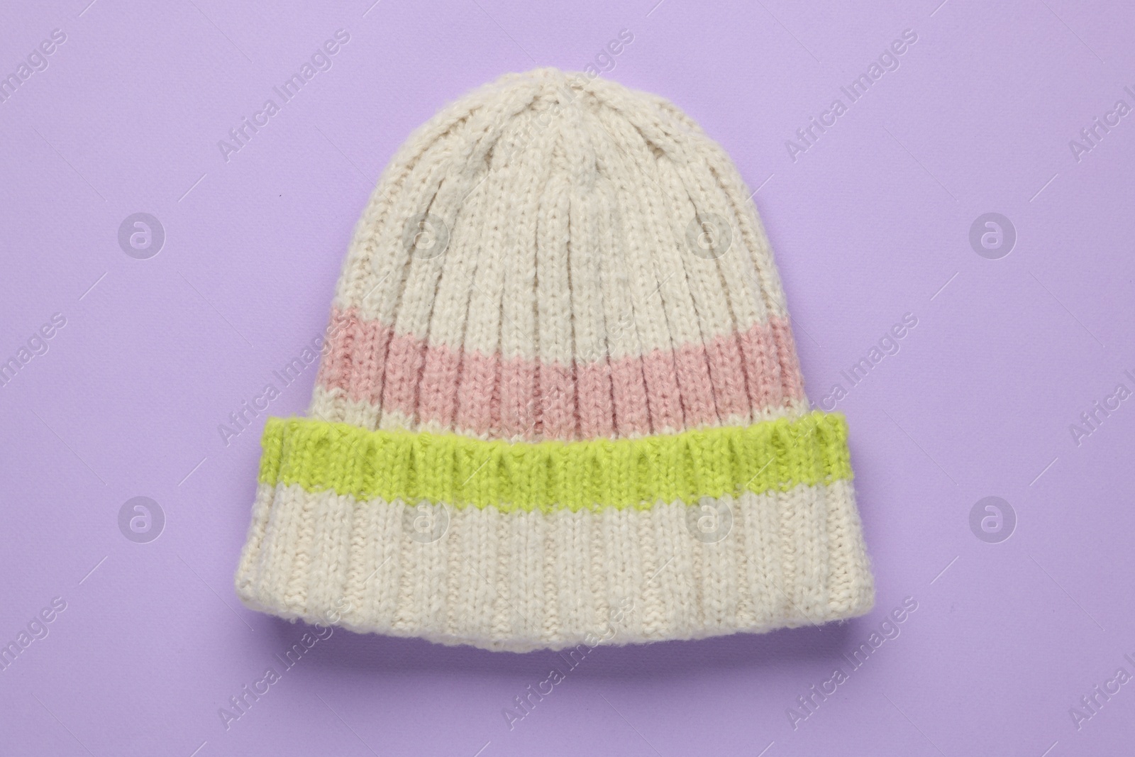 Photo of Warm woolen hat on lilac background, top view