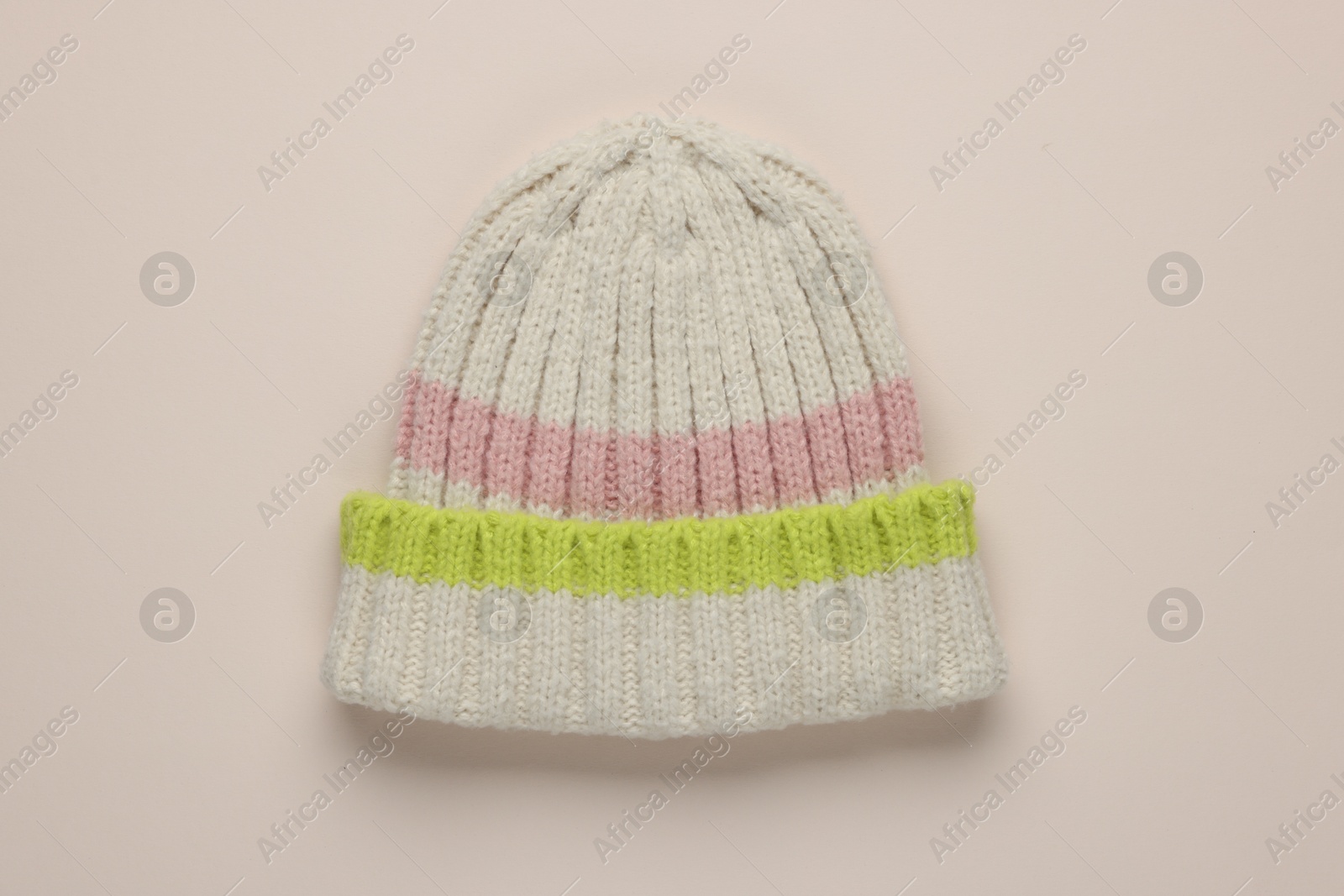 Photo of Warm woolen hat on beige background, top view