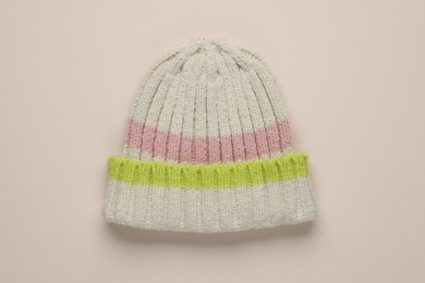 Photo of Warm woolen hat on beige background, top view