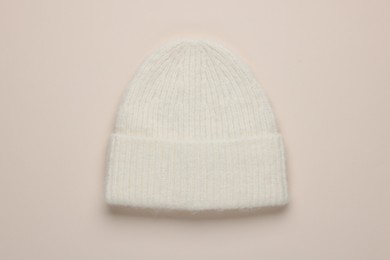 Photo of Warm woolen hat on beige background, top view