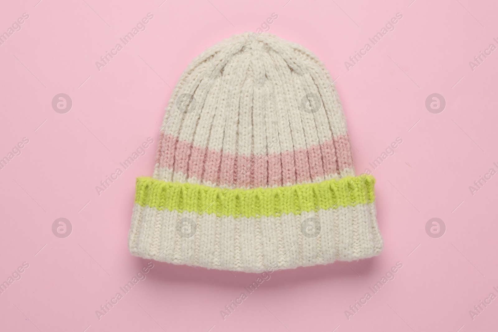 Photo of Warm woolen hat on light pink background, top view