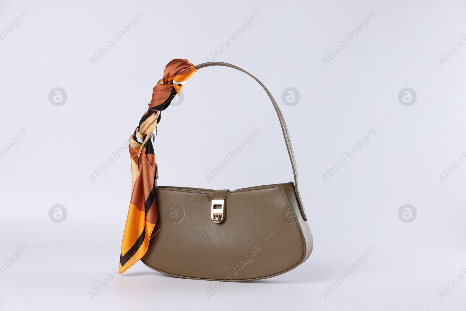 Photo of Elegant women baguette handbag with silk scarf on white background