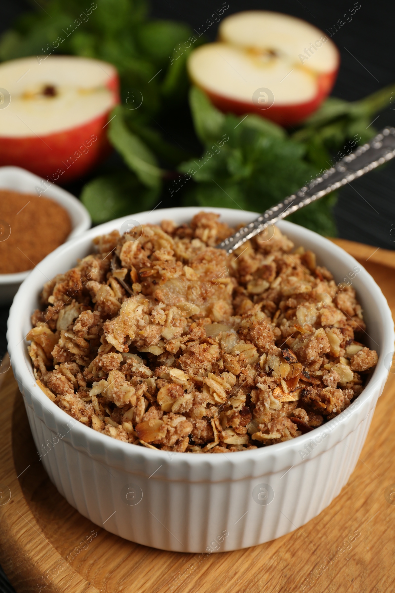 Photo of Delicious apple crisp in bowl on table, closeup