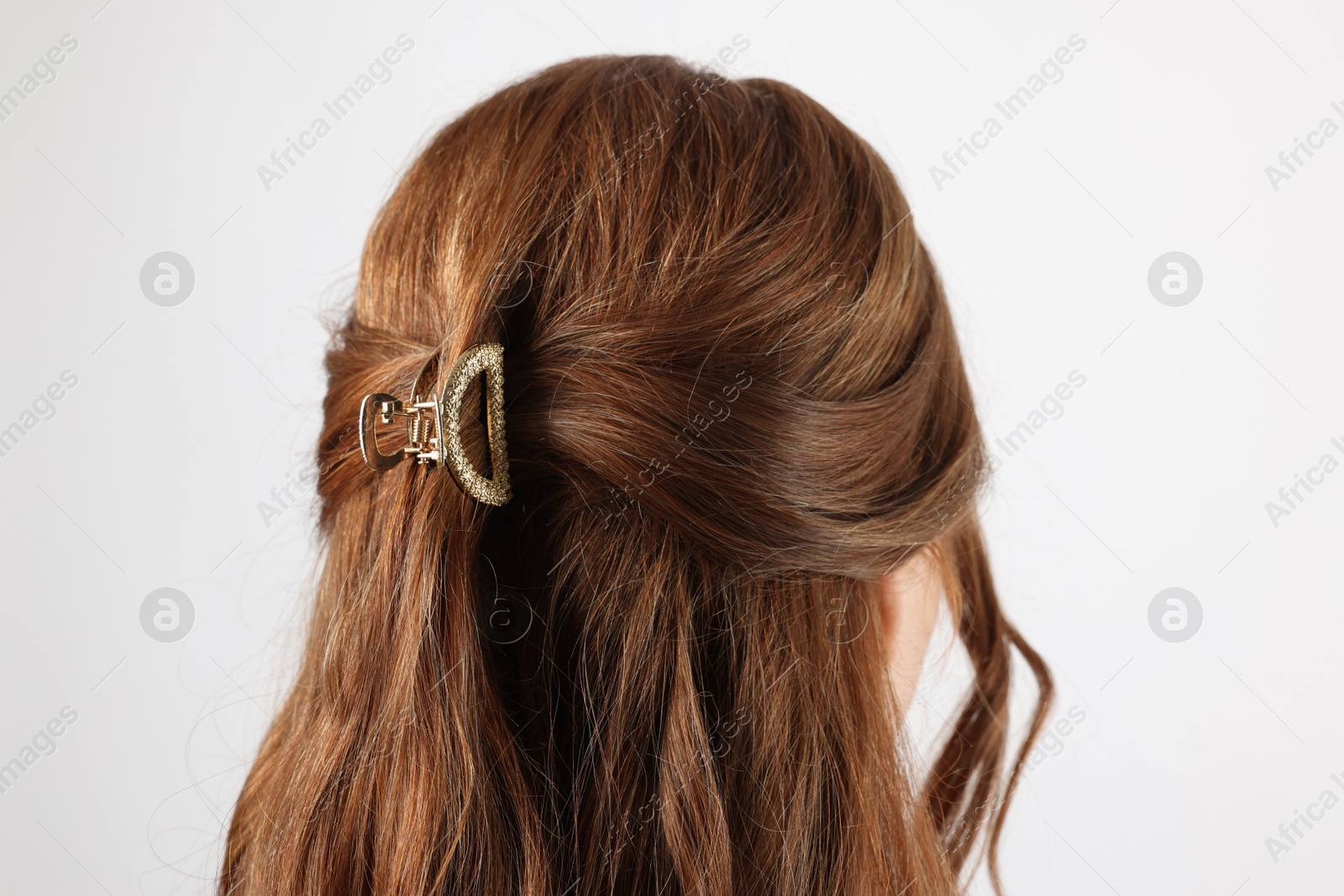 Photo of Teenage girl with stylish hair clip on white background, back view