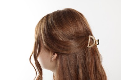 Teenage girl with stylish hair clip on white background, back view