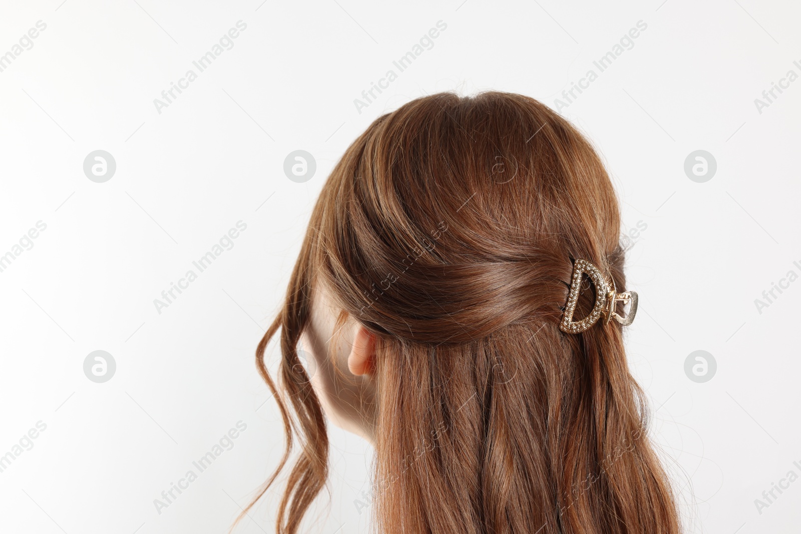 Photo of Teenage girl with stylish hair clip on white background, back view