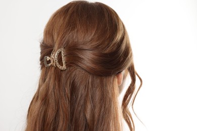 Teenage girl with stylish hair clip on white background, back view