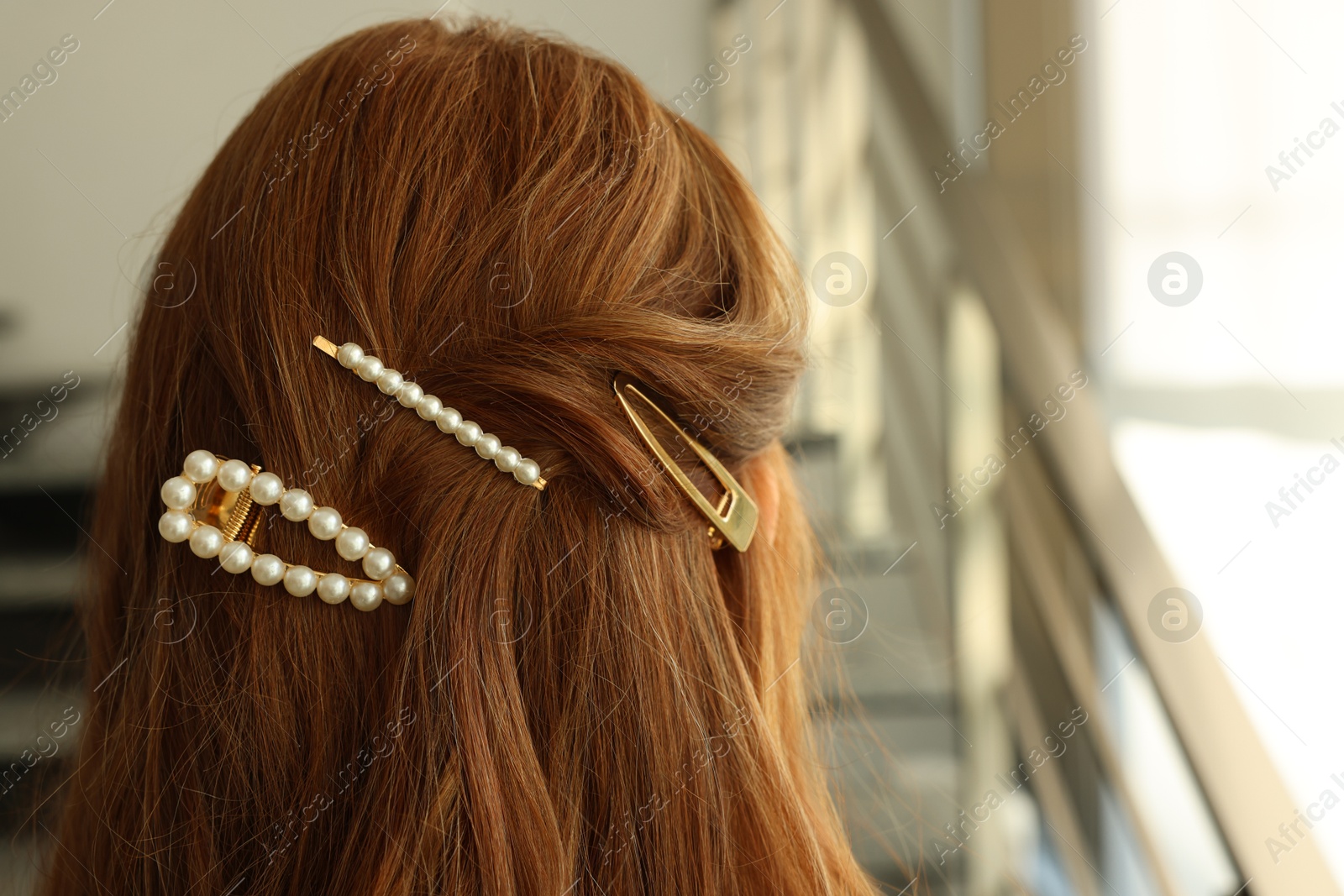 Photo of Teenage girl with stylish hair clips indoors, back view. Space for text