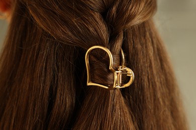 Photo of Teenage girl with stylish hair clip on blurred background, closeup