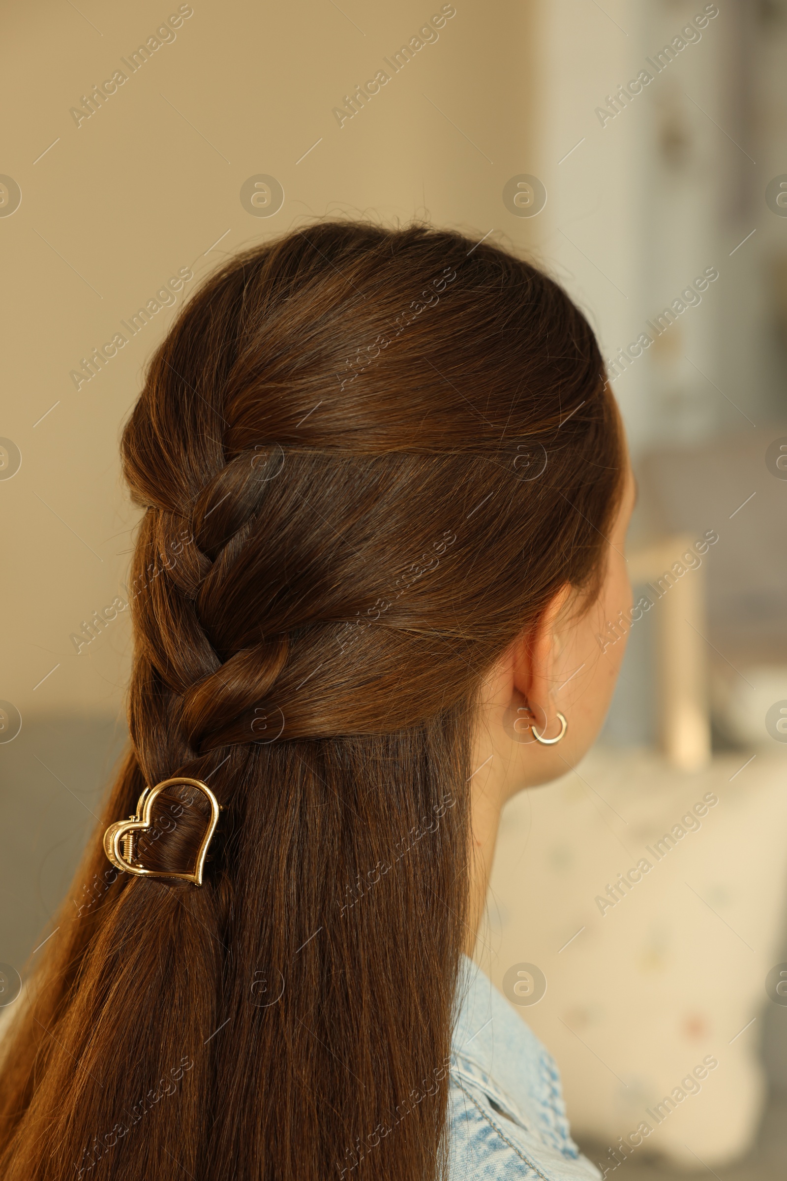 Photo of Teenage girl with stylish hair clip indoors, back view