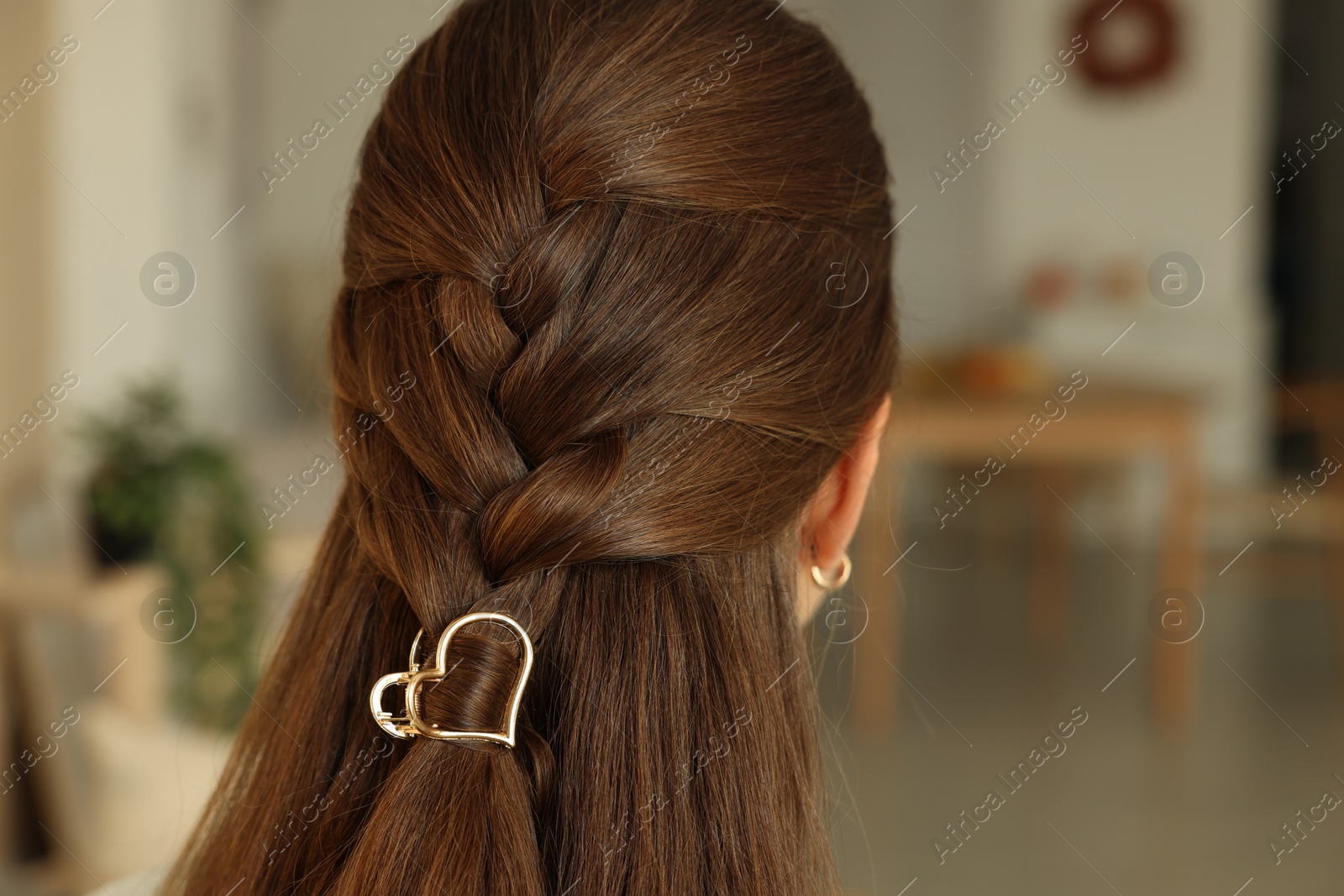 Photo of Teenage girl with stylish hair clip indoors, back view