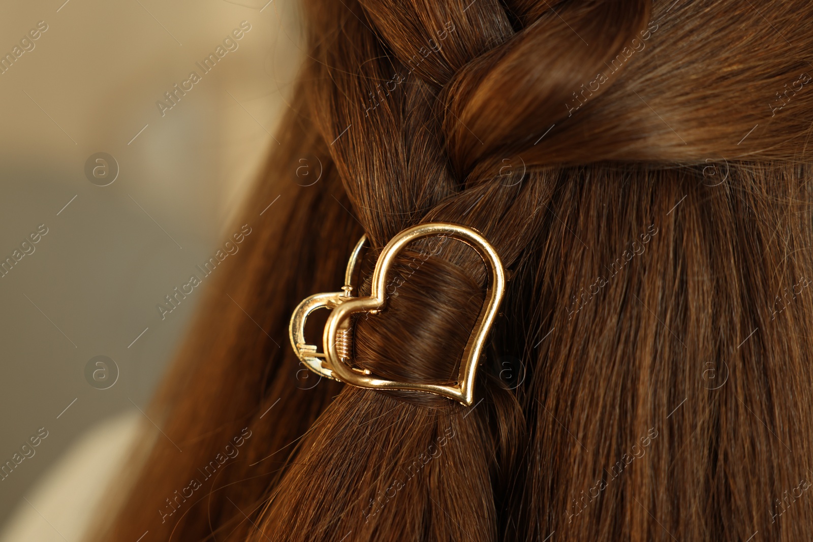 Photo of Teenage girl with stylish hair clip on blurred background, closeup