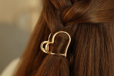 Photo of Teenage girl with stylish hair clip on blurred background, closeup