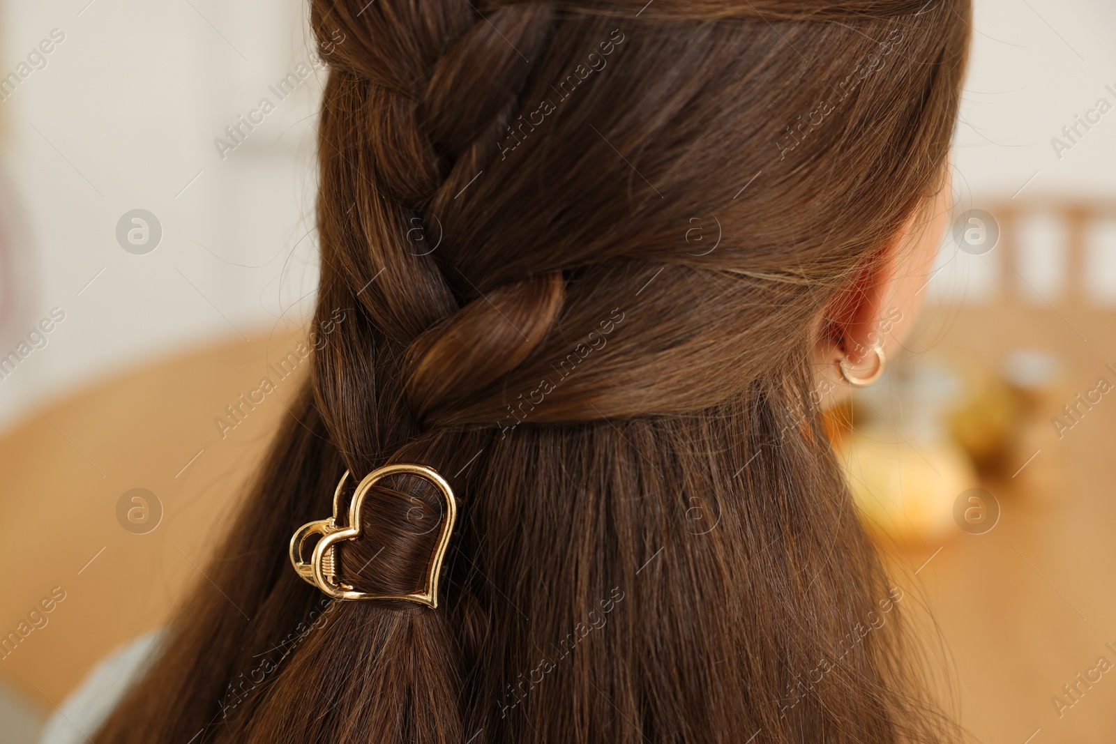 Photo of Teenage girl with stylish hair clip indoors, back view