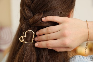 Photo of Teenage girl with stylish hair clip indoors, back view