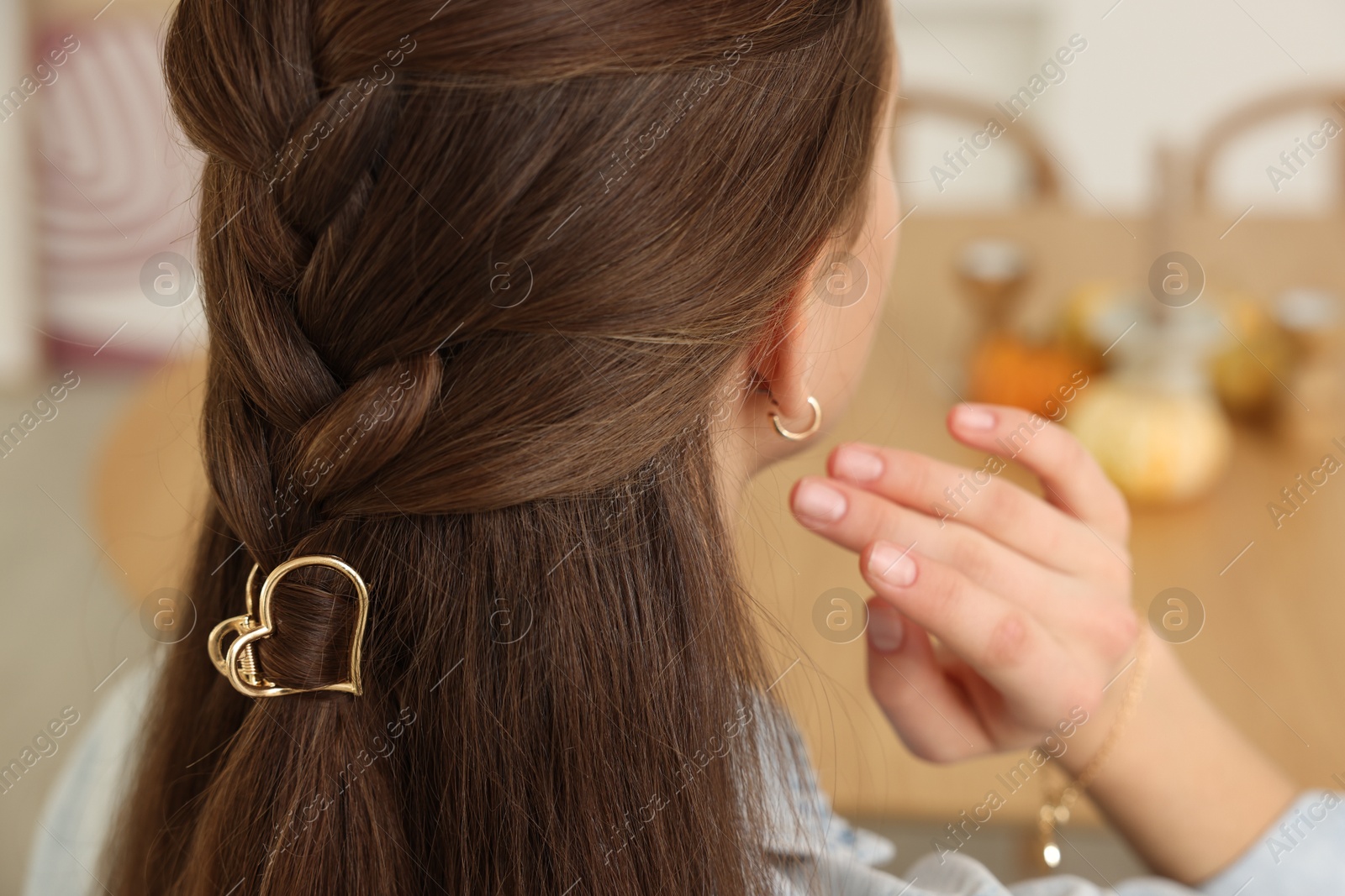 Photo of Teenage girl with stylish hair clip indoors, back view