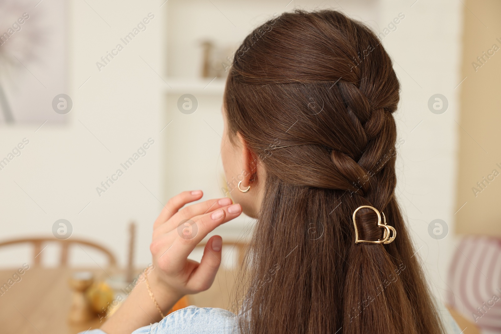 Photo of Teenage girl with stylish hair clip indoors, back view