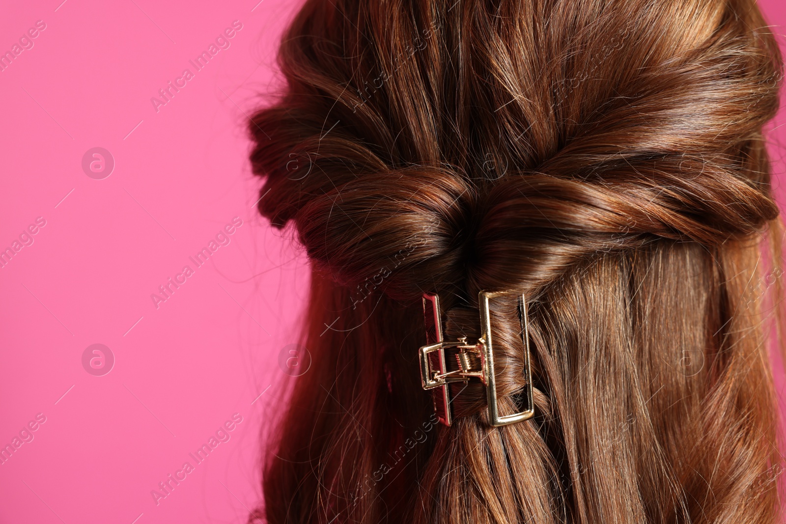 Photo of Teenage girl with stylish hair clip on pink background, back view