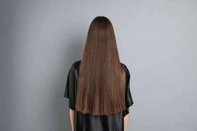 Photo of Teenage girl with healthy long hair on light grey background, back view