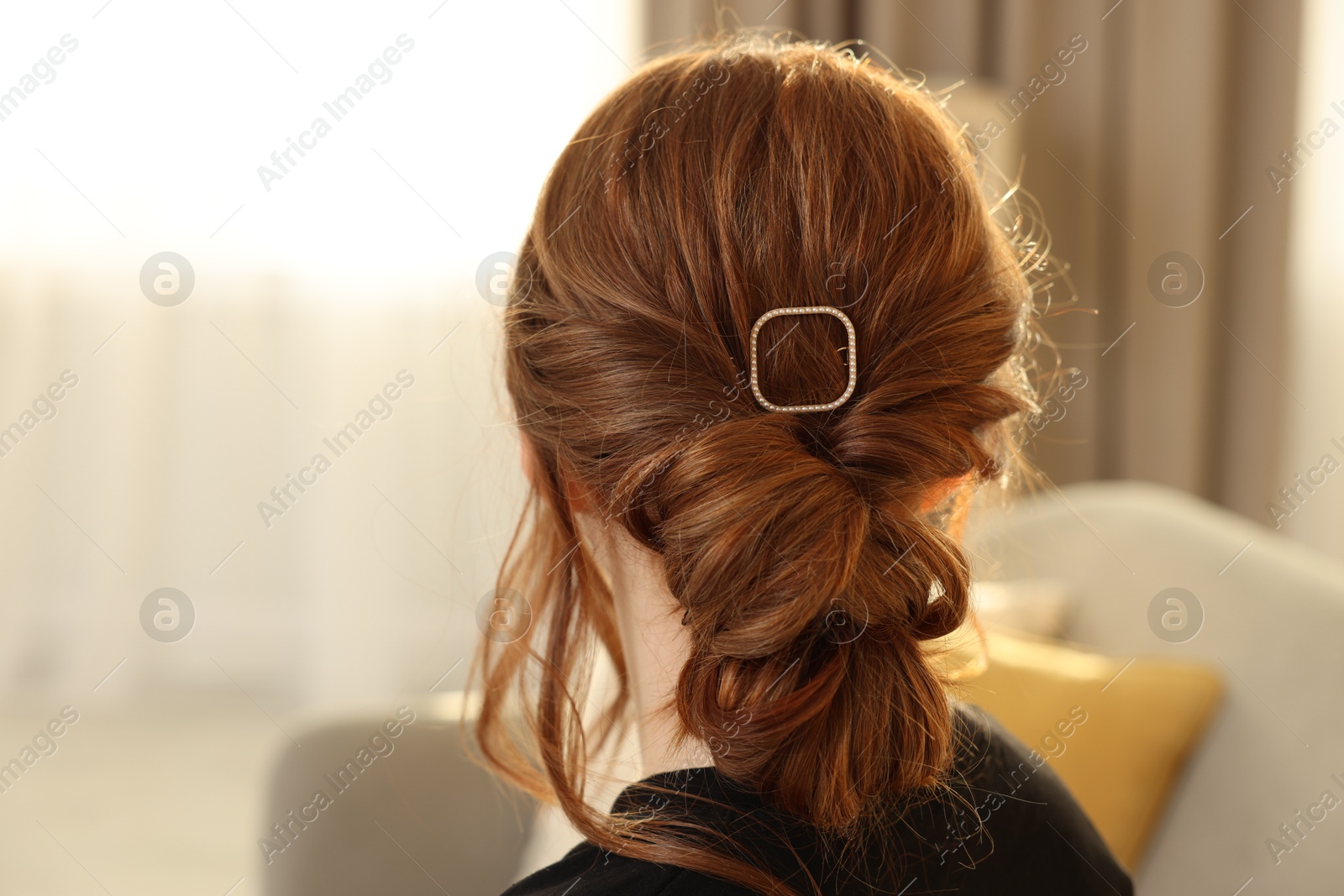 Photo of Teenage girl with stylish hair clip indoors, back view