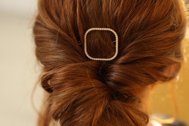 Photo of Teenage girl with stylish hair clip indoors, back view