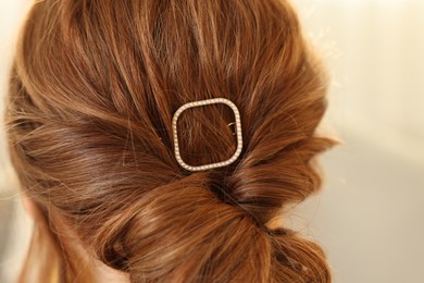 Photo of Teenage girl with stylish hair clip indoors, back view