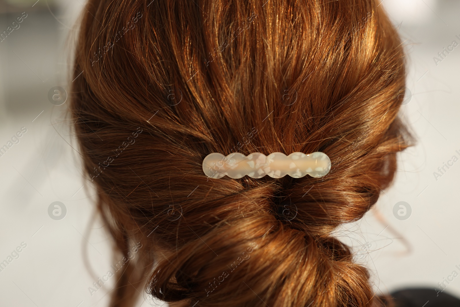 Photo of Teenage girl with stylish hair clip indoors, back view