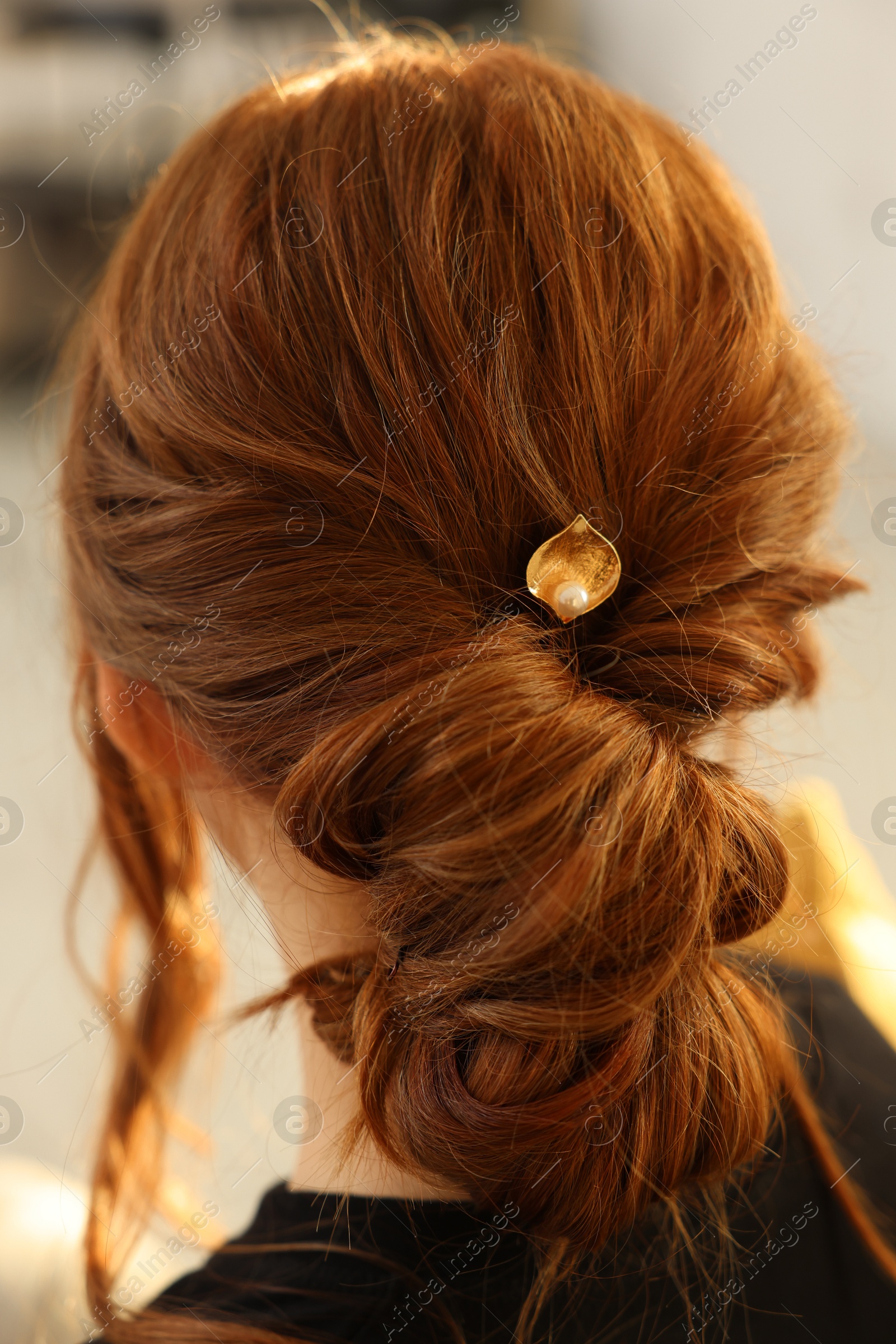 Photo of Teenage girl with stylish hair clip indoors, back view