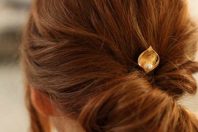 Photo of Teenage girl with stylish hair clip indoors, back view