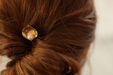 Photo of Teenage girl with stylish hair clip indoors, back view