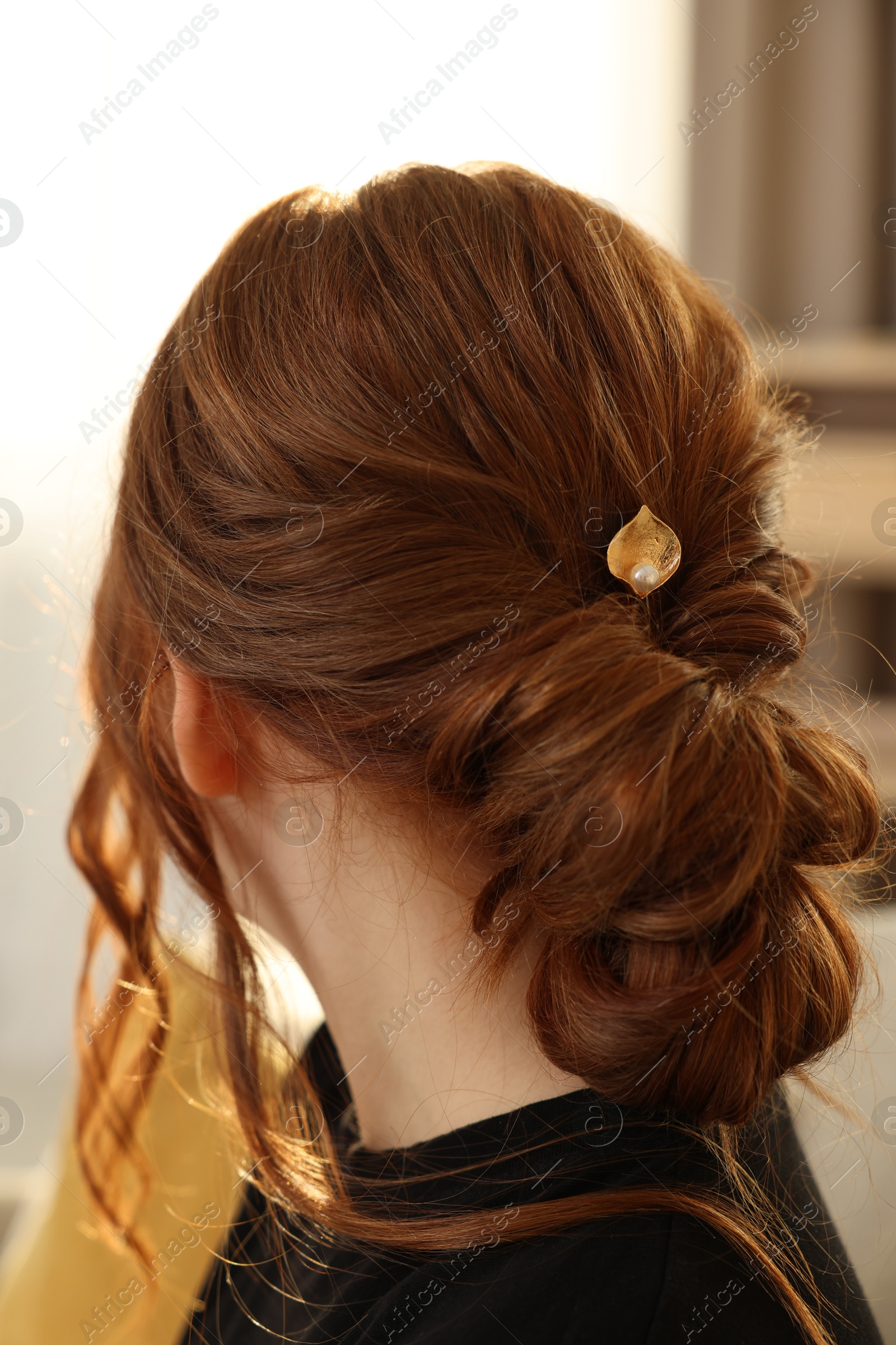 Photo of Teenage girl with stylish hair clip indoors, back view