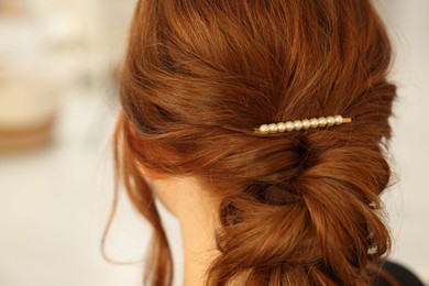 Photo of Teenage girl with stylish hair clip indoors, back view