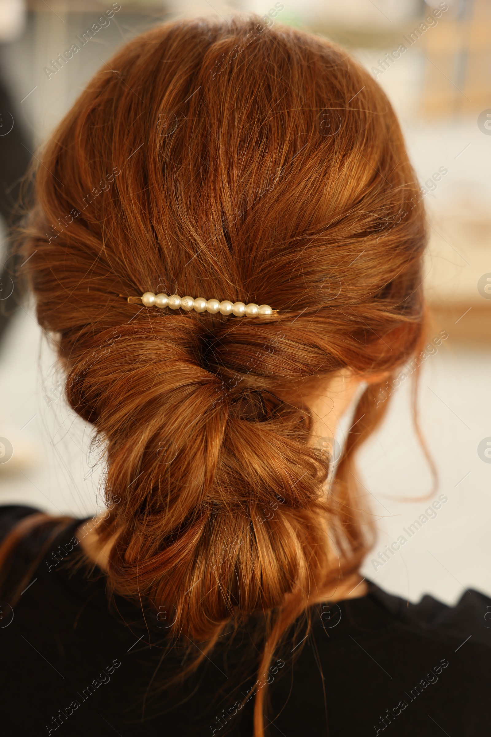 Photo of Teenage girl with stylish hair clip indoors, back view